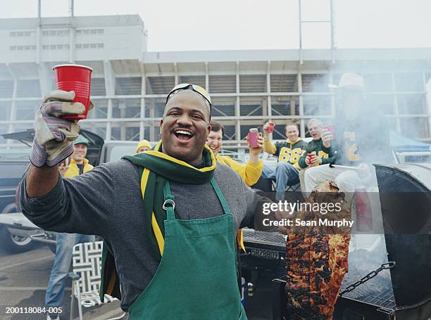 men having barbeque at tailgate party in stadium parking lot - costeleta comida imagens e fotografias de stock