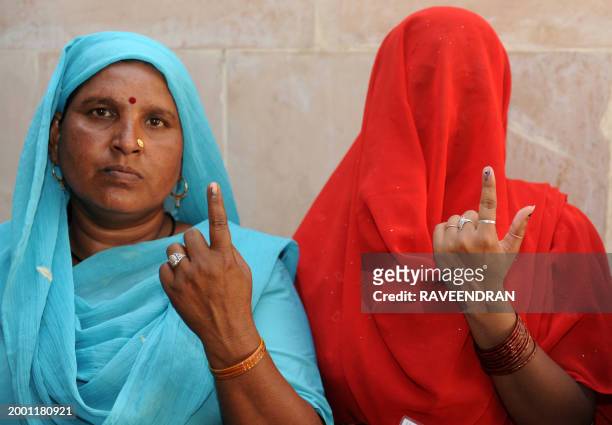 Indian voters show their fingers marked with indelible ink as they leave a polling station in Chandigarh on May 13 after casting their votes during...