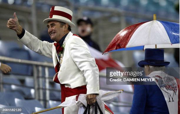 An English fan jubilates past a French fan after the Rugby World Cup semi-final match between France and England, 16 November 2003 at Olympic Park...