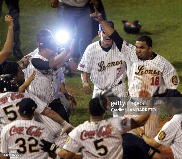 Alex Gonzalez of the Lions of Caracas is surrounded by teammates as he crosses home plate to score the winning run against the Tigres of Licey in...