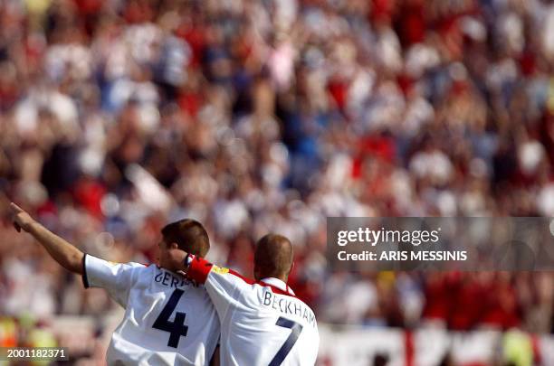 England's midfielder and captain David Beckham congratulates his teammate midfielder Steven Gerrard after his goal, 17 June 2004 at Coimbra's...