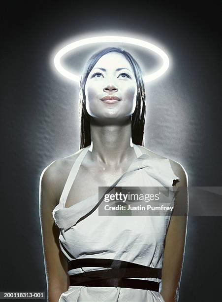 young woman with halo of flourescent light illuminating face - halo symbol stock pictures, royalty-free photos & images