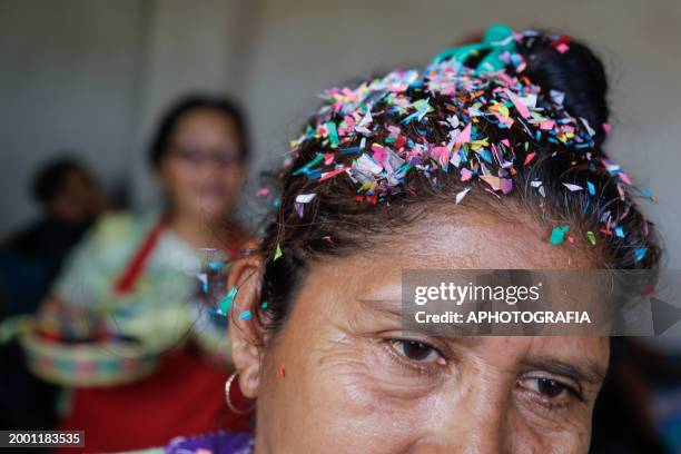 Woman looks on with her hair full of confetti during the celebration of 'Fiesta de las Comadres', also known as 'Martes de Carnaval' in Izalco on...