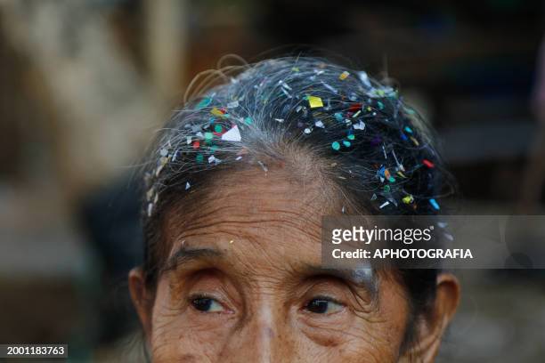 Woman with her hair full of confetti looks on during the celebration of 'Fiesta de las Comadres', also known as 'Martes de Carnaval' in Izalco on...