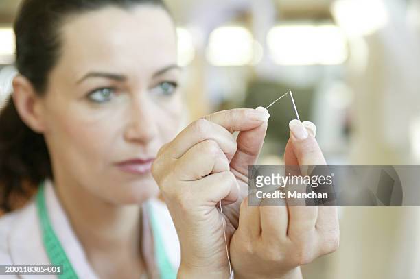 woman, focus on hands threading needle - threading stock pictures, royalty-free photos & images