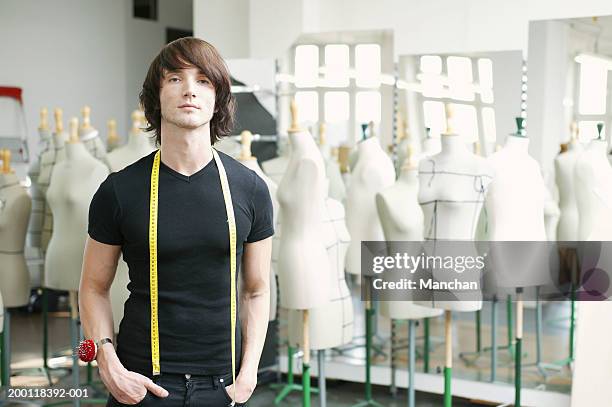 man with tape measure round neck in fashion studio, portrait - draft portraits stock-fotos und bilder