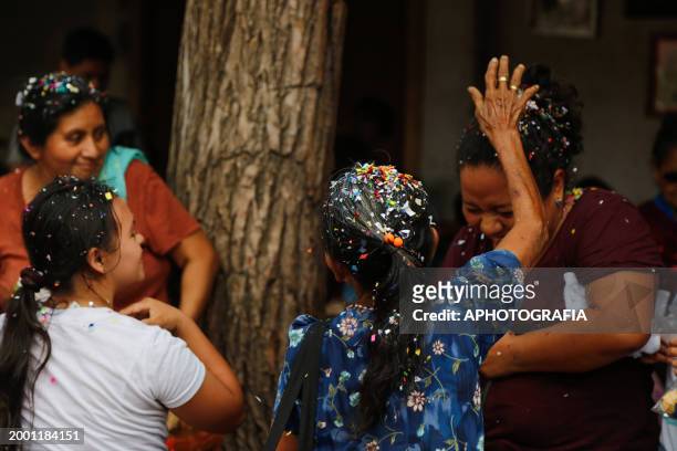 Little girl throws confetti-filled eggshells at her mother during the celebration of 'Fiesta de las Comadres', also known as 'Martes de Carnaval' in...