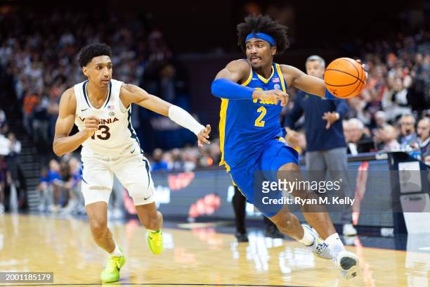 Blake Hinson of the Pittsburgh Panthers drives around Ryan Dunn of the Virginia Cavaliers in the first half at John Paul Jones Arena on February 13,...