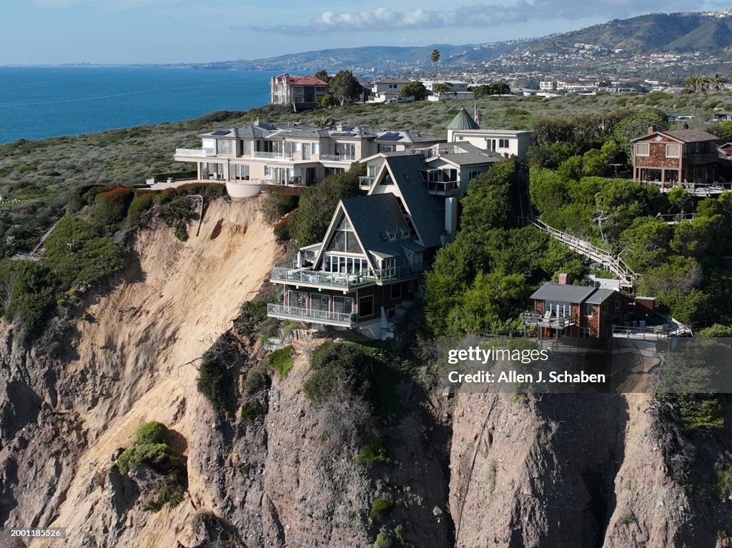 Aerial view of three large homes in Dana Point that are in danger of falling into the ocean after a cliffside gave way over the weekend.