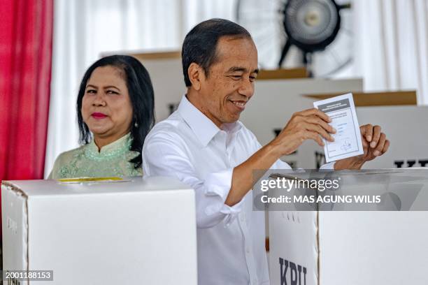 Indonesian President Joko Widodo and his wife Iriana cast their ballot during the presidential and legislative elections at a polling station at the...