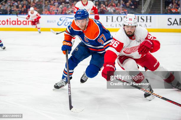 Connor McDavid of the Edmonton Oilers and Jake Walman of the Detroit Red Wings battle for the puck during the second period at Rogers Place on...