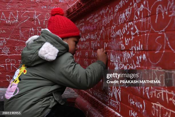 Writes a message with chalk on a wall at the Saraswati temple on the occasion of the Hindu festival of 'Basanta Panchami', in Kathmandu on February...