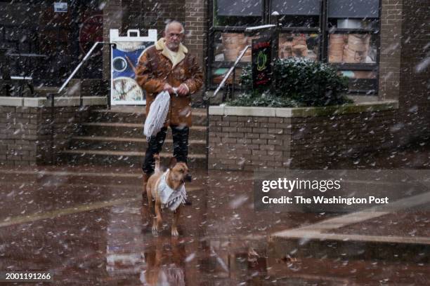 Ramzi II Al-Naddeh Al Hashemite and his dog, Zoltan, pass through Lake Anne Plaza as heavy snow falls for a short period in the Washington, DC, area...