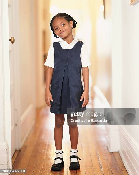 girl (6-8) wearing school uniform in hallway, portrait - uniform stockfoto's en -beelden