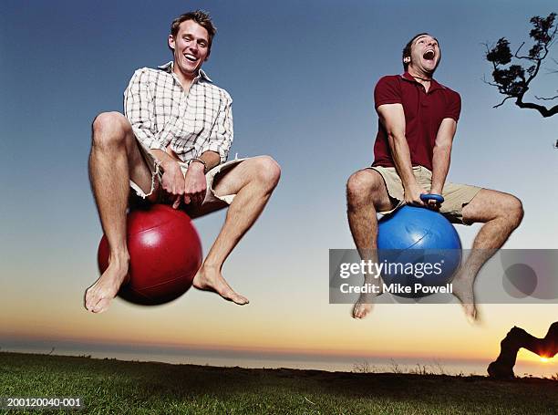 two young men playing with bounce and hop balls - bouncing stockfoto's en -beelden