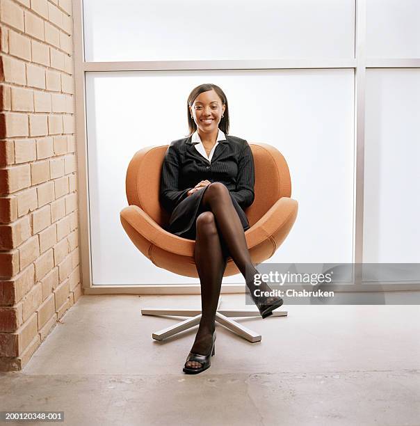 young business woman sitting in chair smiling, portrait - black woman full length stock pictures, royalty-free photos & images