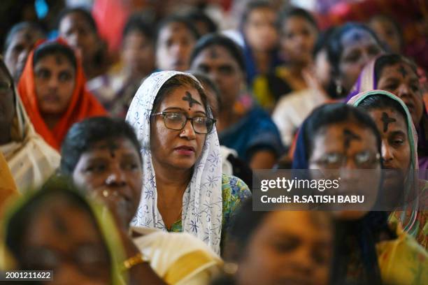 Christian devotees with a cross symbol made with ash on their foreheads attend an Ash Wednesday mass service at St. Thomas Cathedral Basilica in...