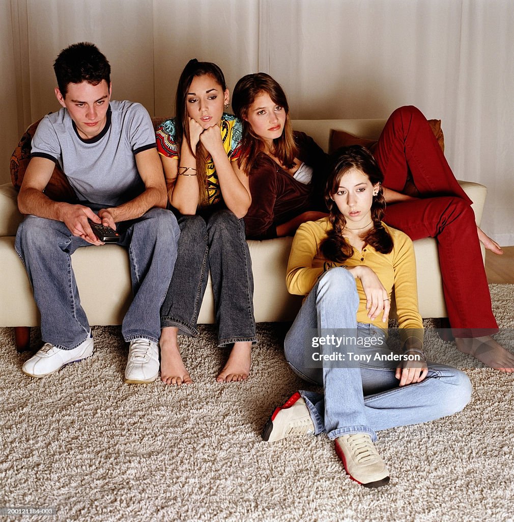 Four teenagers watching television