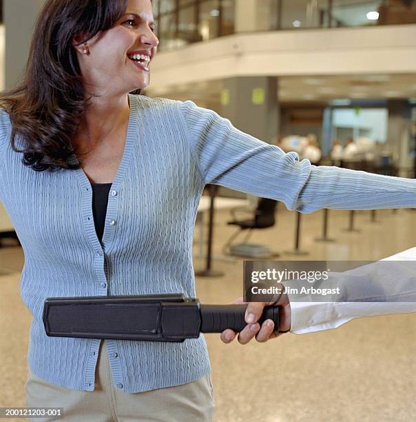 woman being swiped by metal detector at airport security checkpoint - security scanner stock pictures, royalty-free photos & images