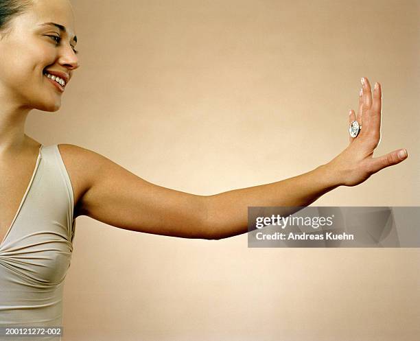 woman looking at hand with large diamond ring, close up - admiration photos et images de collection