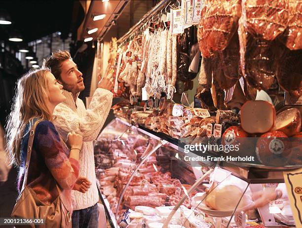 Portrait Of A Female Butcher Cutting A Piece Of Meat In Butchers