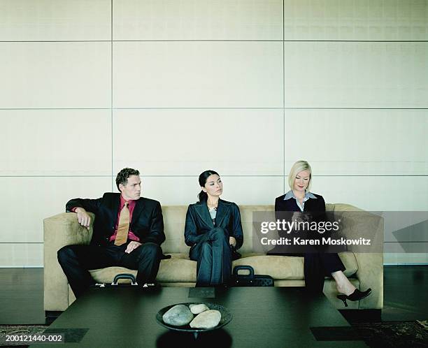 business people seated on couch watching woman use hand-held computer - purple suit woman stock pictures, royalty-free photos & images