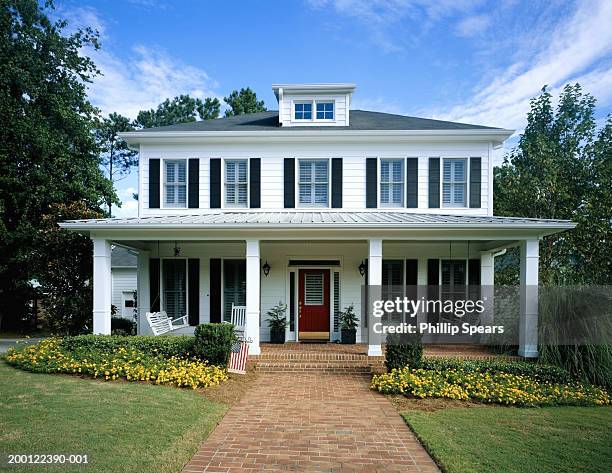 white wooden house, flowers blooming around front porch - facade foto e immagini stock