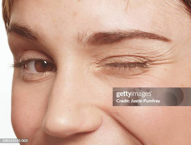 young woman winking, portrait, close-up - winking stock pictures, royalty-free photos & images