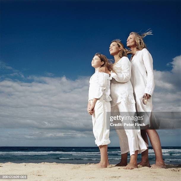 mother, daughter (8-10) and grandmother on beach, side view - three girls at beach stock pictures, royalty-free photos & images