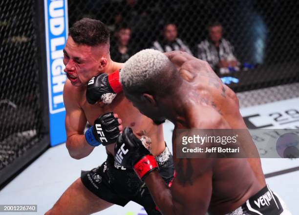 Bolaji Oki of Belgium punches Timmy Cuamba in a lightweight fight during the UFC Fight Night event at UFC APEX on February 10, 2024 in Las Vegas,...