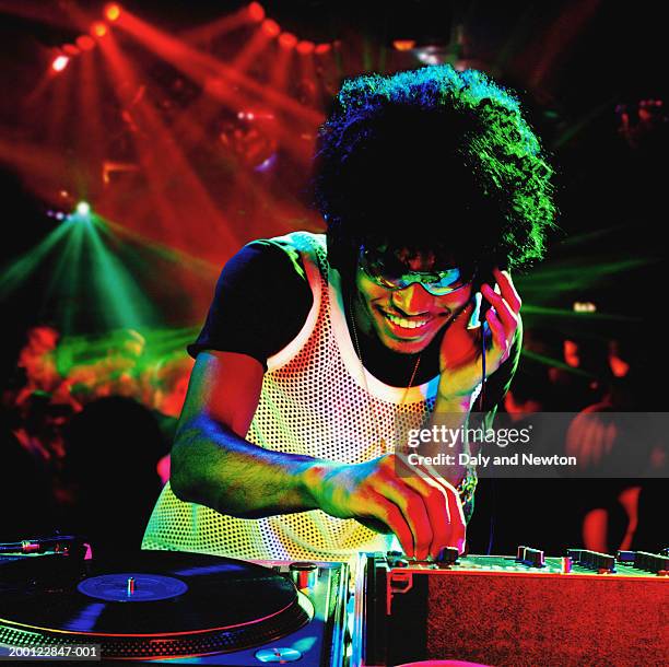 young male dj using record decks in nightclub - black dj stock pictures, royalty-free photos & images