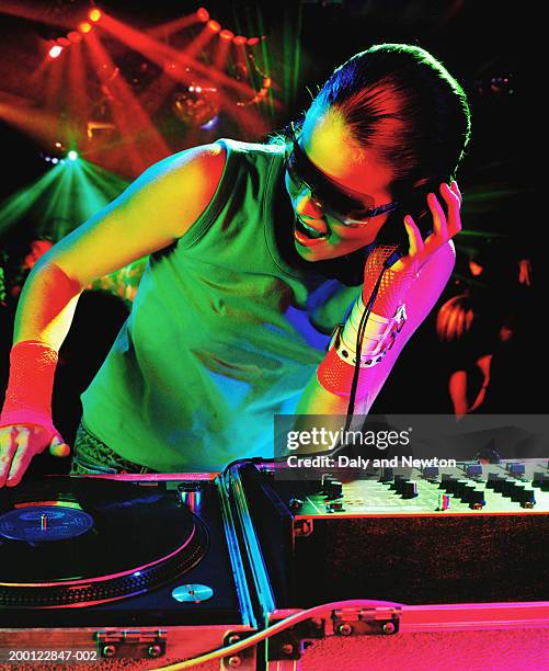 young female dj using record decks in nightclub - dance music stock pictures, royalty-free photos & images