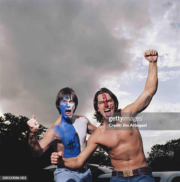 opposing sports fans wearing face paint, cheering, portrait - opposition party stock-fotos und bilder