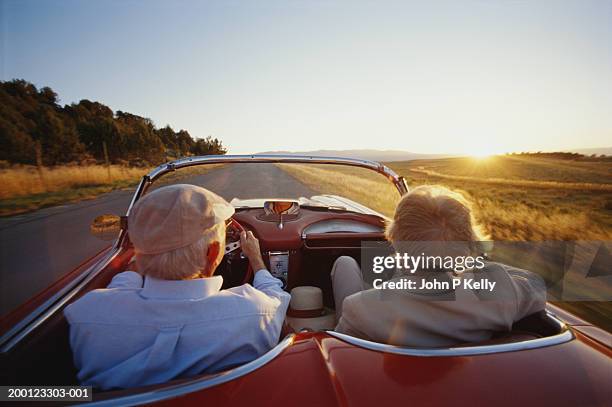 mature couple in car, rear view - convertible stockfoto's en -beelden