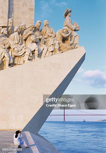 portugal, lisbon, woman photographing monument to the discoveries - provincie lissabon stockfoto's en -beelden