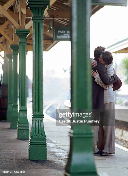 couple embracing on train platform - travel2 stock pictures, royalty-free photos & images