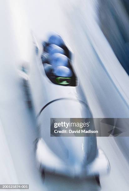 four-man bobsled team racing down course (blurred motion) - bobsleigh team stock pictures, royalty-free photos & images