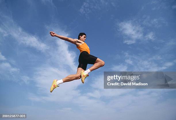 male long jumper in mid-air, low angle view - mens long jump - fotografias e filmes do acervo