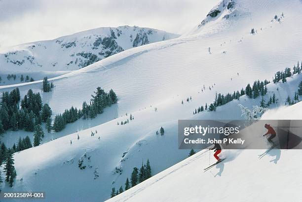 two men skiing down mountain - californian sierra nevada stock-fotos und bilder