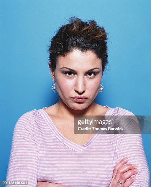 woman with arms folded across chest and lips puckered, portrait - malumore foto e immagini stock