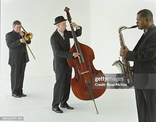 jazz band playing saxophone, trombone, and bass - jazz band photos et images de collection