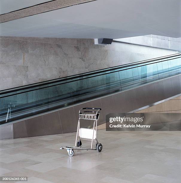 luggage trolley by escalator - carrello a mano foto e immagini stock