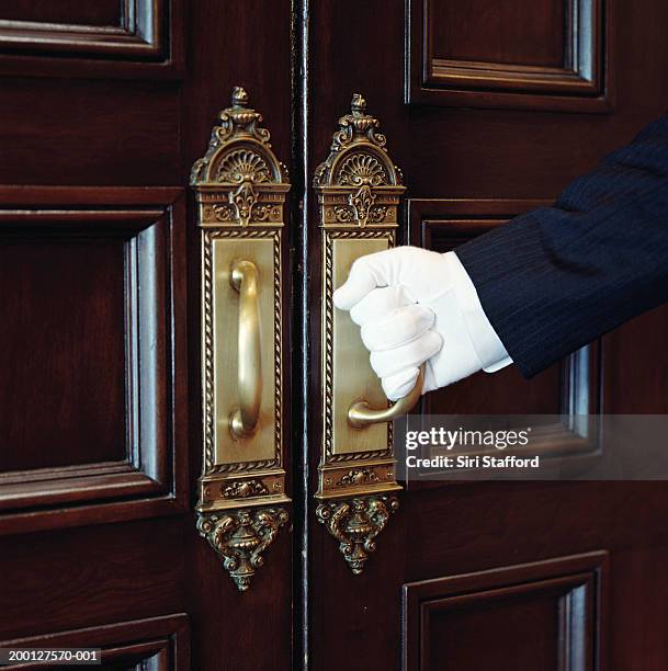 man wearing white gloves, opening door, close-up - maggiordomo foto e immagini stock