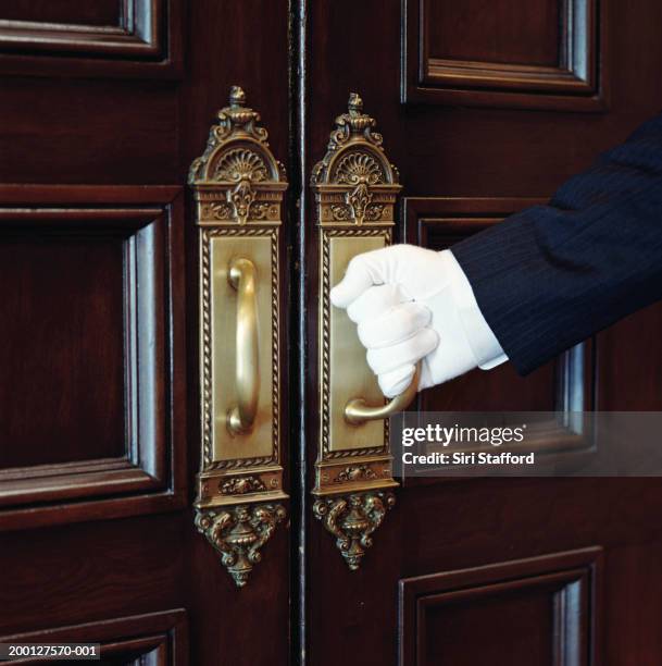 man wearing white gloves, opening door, close-up - doorman stockfoto's en -beelden