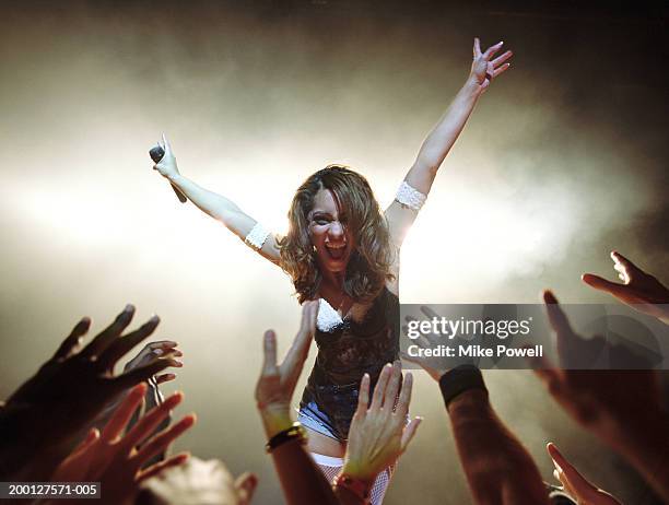 singer leaning towards fans, low angle - crowd surfing stock-fotos und bilder