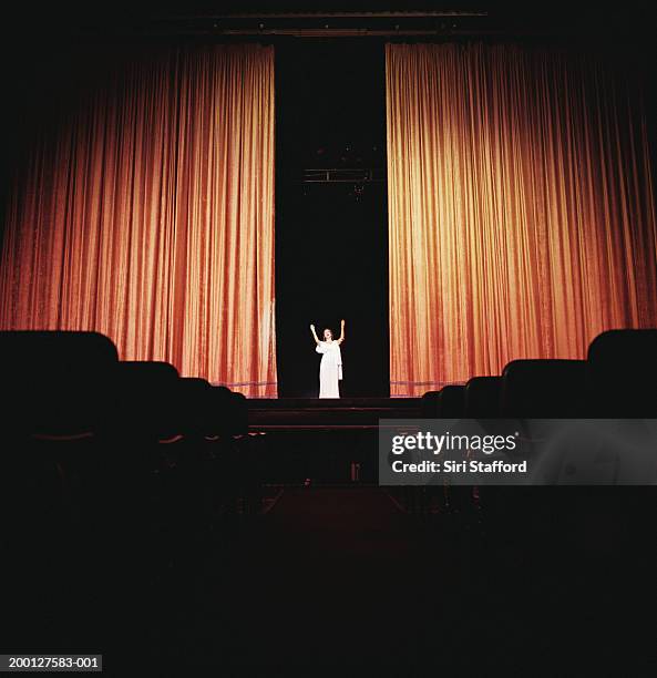 opera singer standing between curtains on stage - opéra photos et images de collection