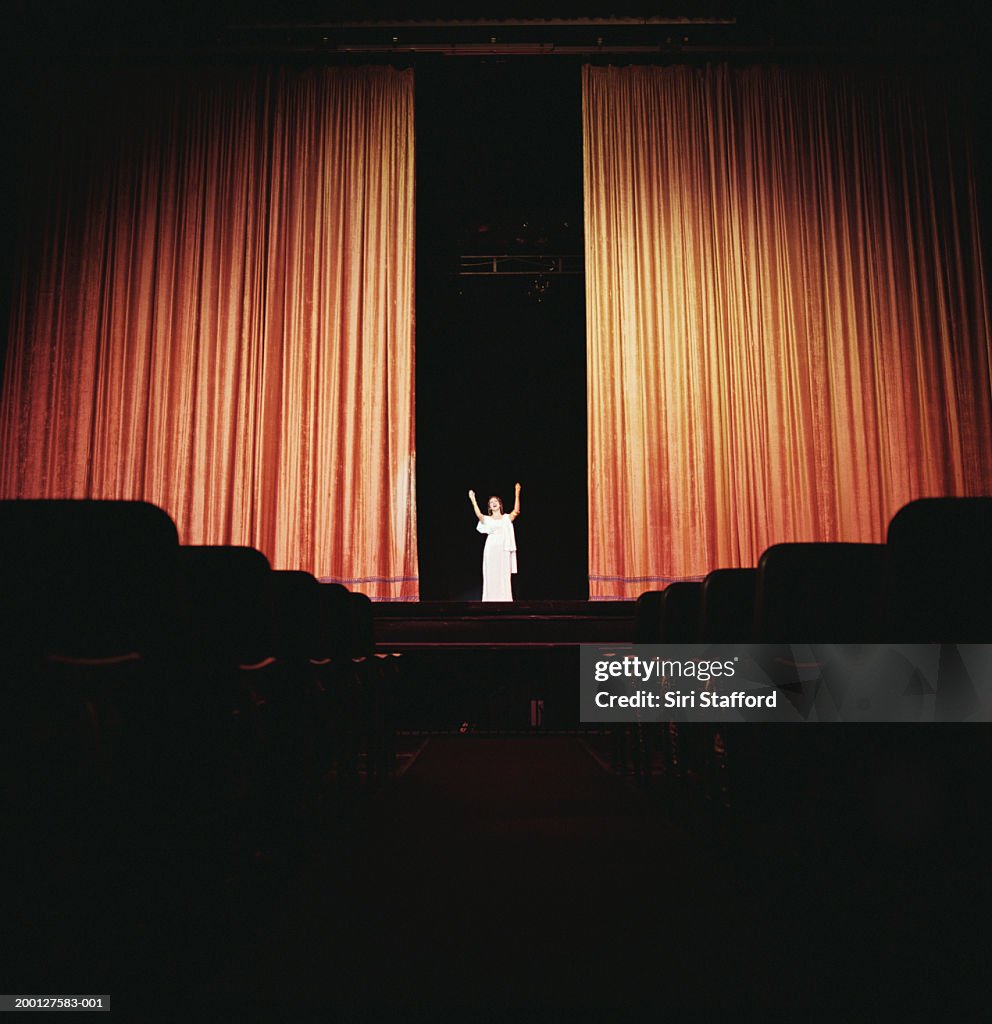 Opera singer standing between curtains on stage