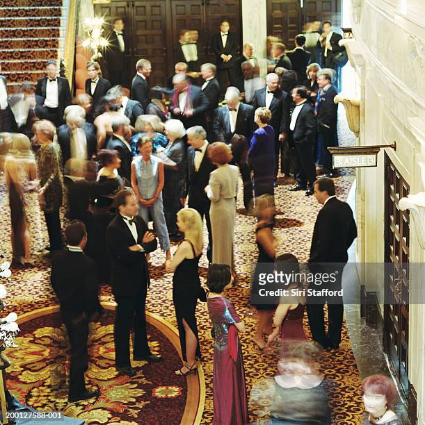 theater goers in formal attire, waiting in lobby - black tie party fancy stock-fotos und bilder