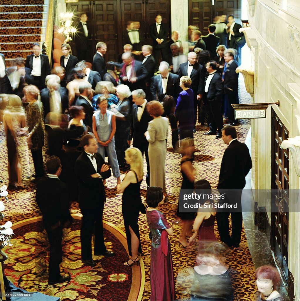 Theater goers in formal attire, waiting in lobby