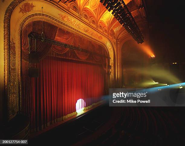 spotlight shining on curtain of theater - teatro fotografías e imágenes de stock